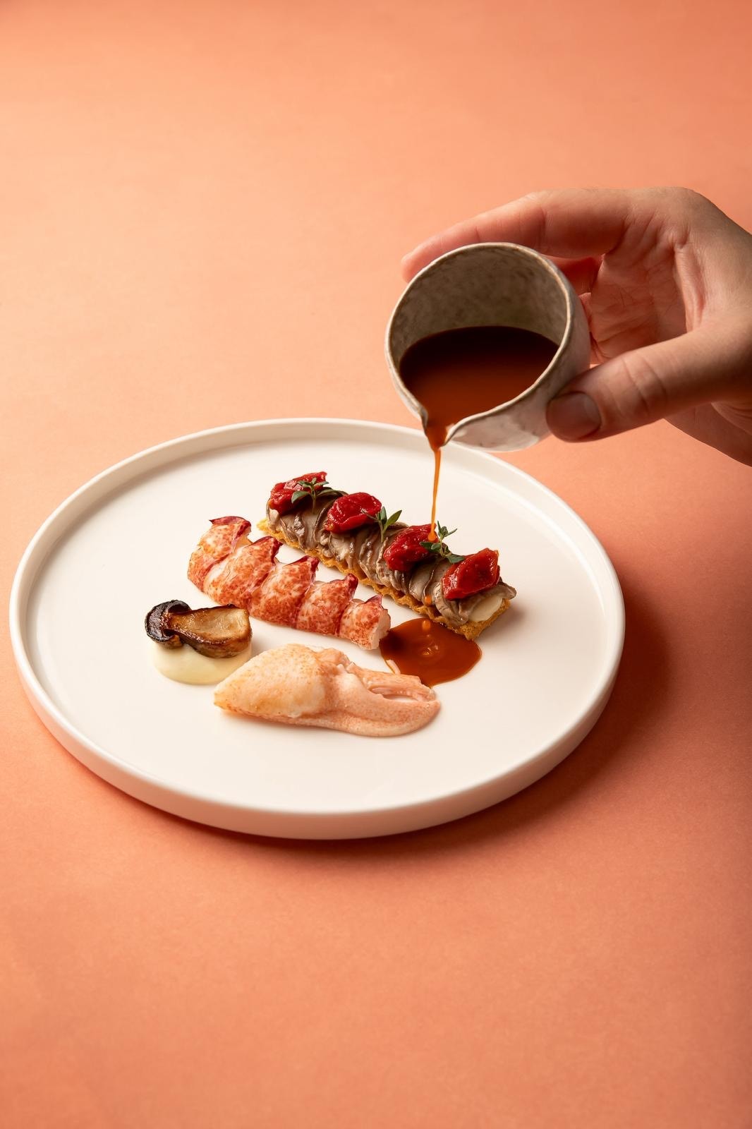 Sauce being poured over lobster dish